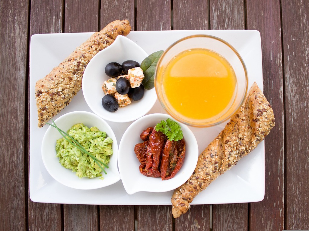 Imagen de un desayuno con zumo, frutas, pan integral...